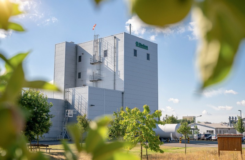 Produktionsanlage zwischen Grünflachen bei Sonnenschein