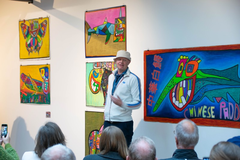 Mann steht vor Kunst auf einer Art Erhöhung