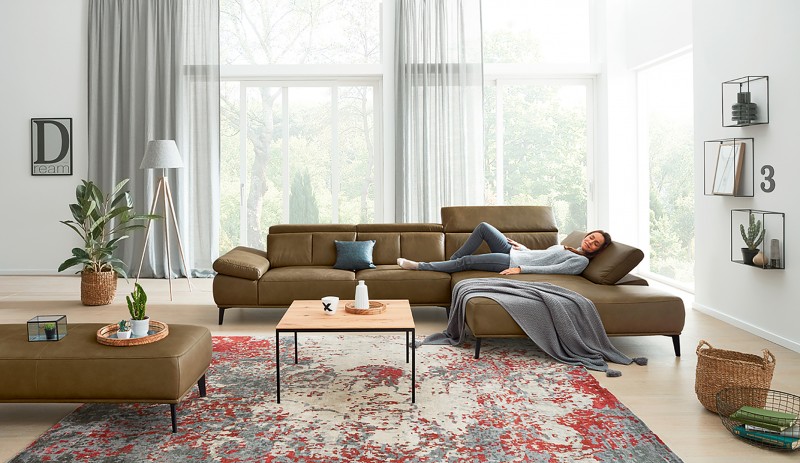 Person liegt auf einem Sofa im Wohnzimmer