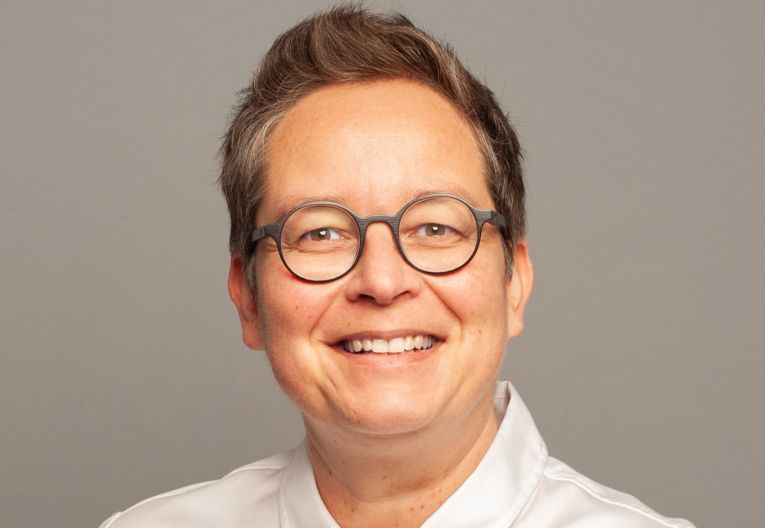 Frau mit Brille lächelt in Kamera