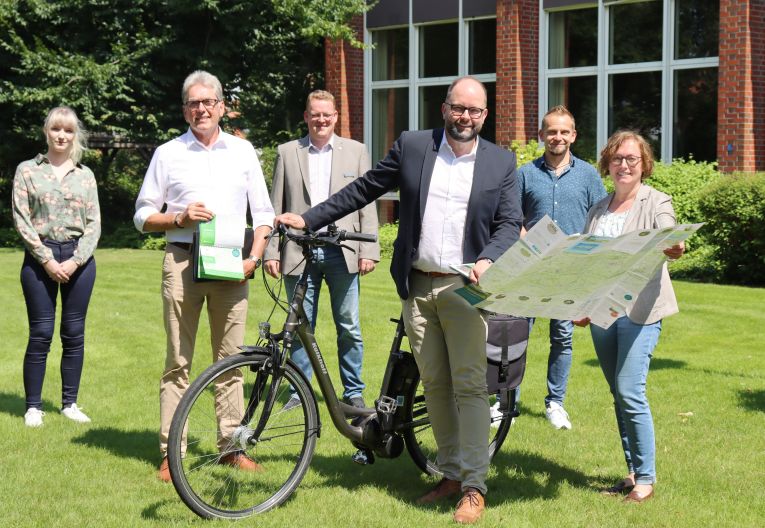 Gruppenbild Landrat aus Cloppenburg mit Fahrrad, Radwanderkarten und fünf weiteren Personen
