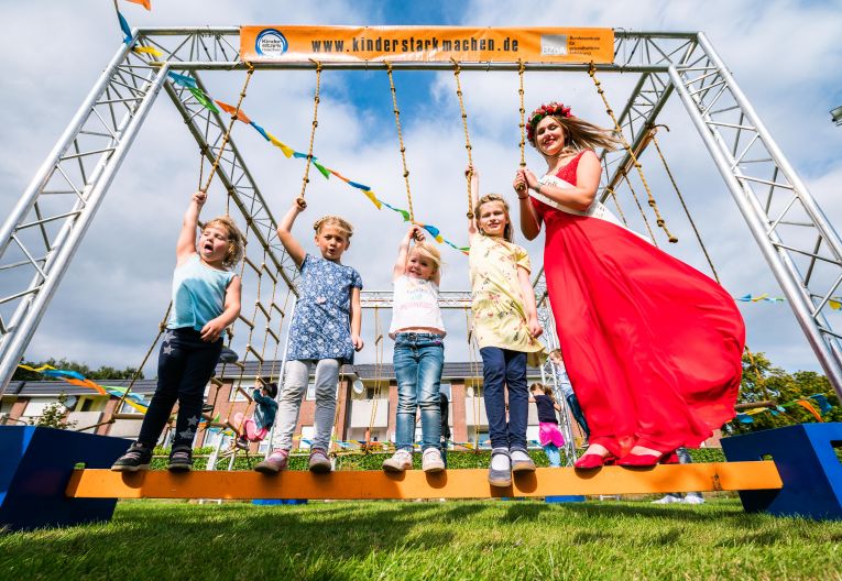 Familientag Oldenburger Münsterland 2019 vier Kinder auf einem Klettergerüst mit der Erdbeerkönigin 