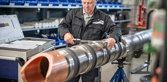 Ein Mann der an einem Rohr arbeitet